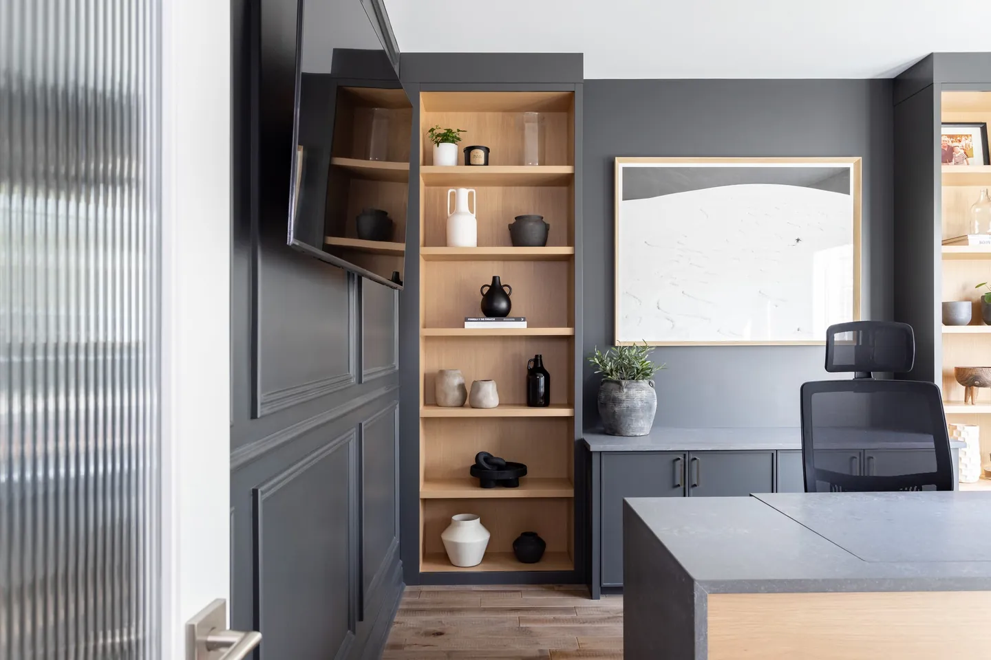 Charcoal built-in office with oak shelves and a framed print