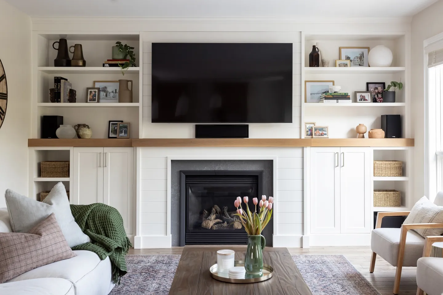 Fireplace wall with built-in shelving and an oak mantel