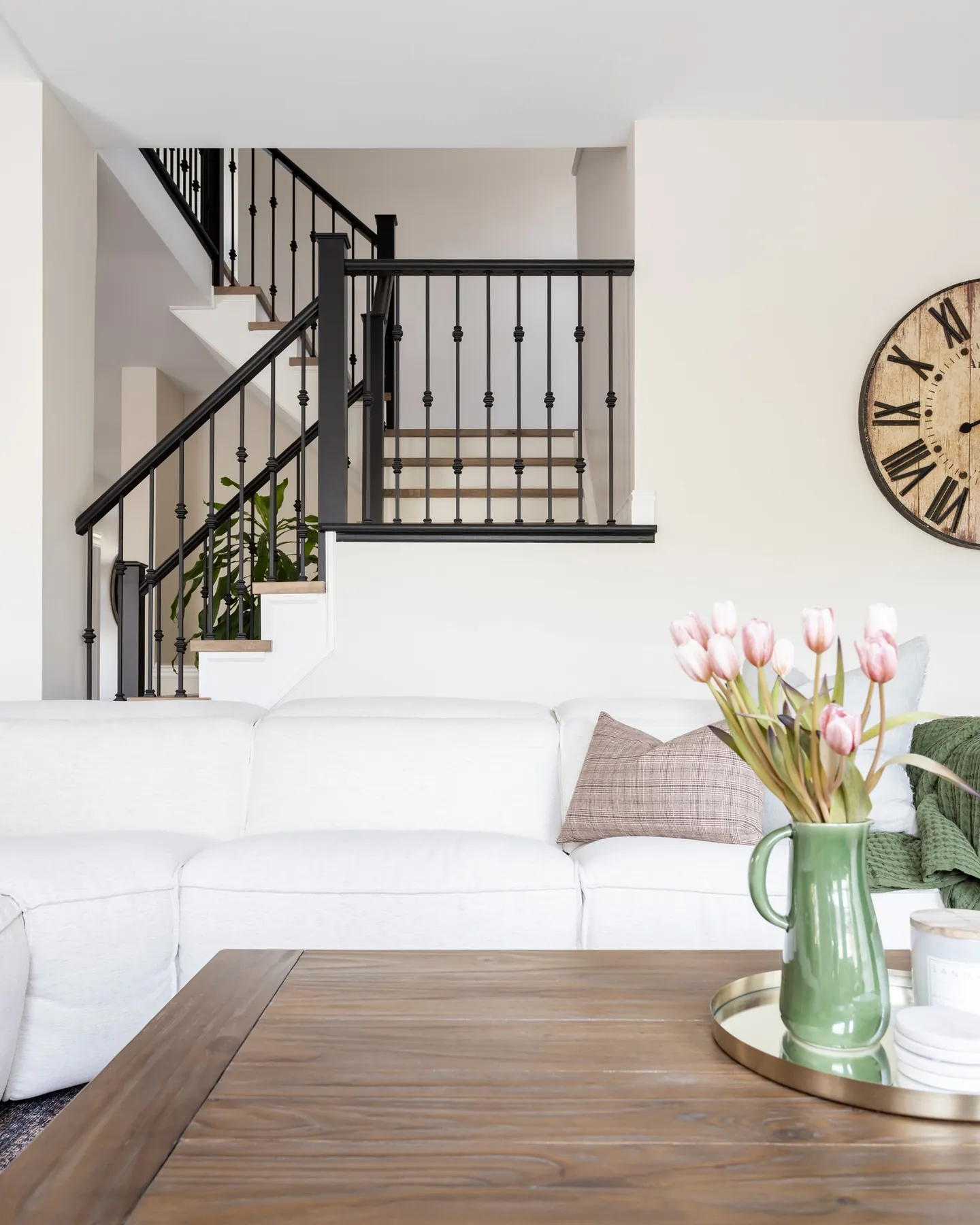 Staircase with black metal spindles beside a white sofa