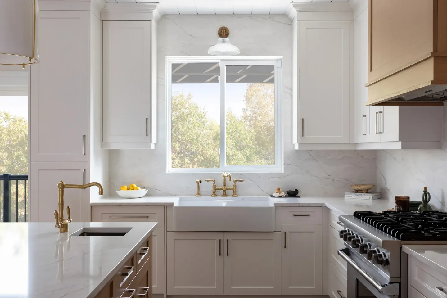 White kitchen with a farmhouse sink below a bright window