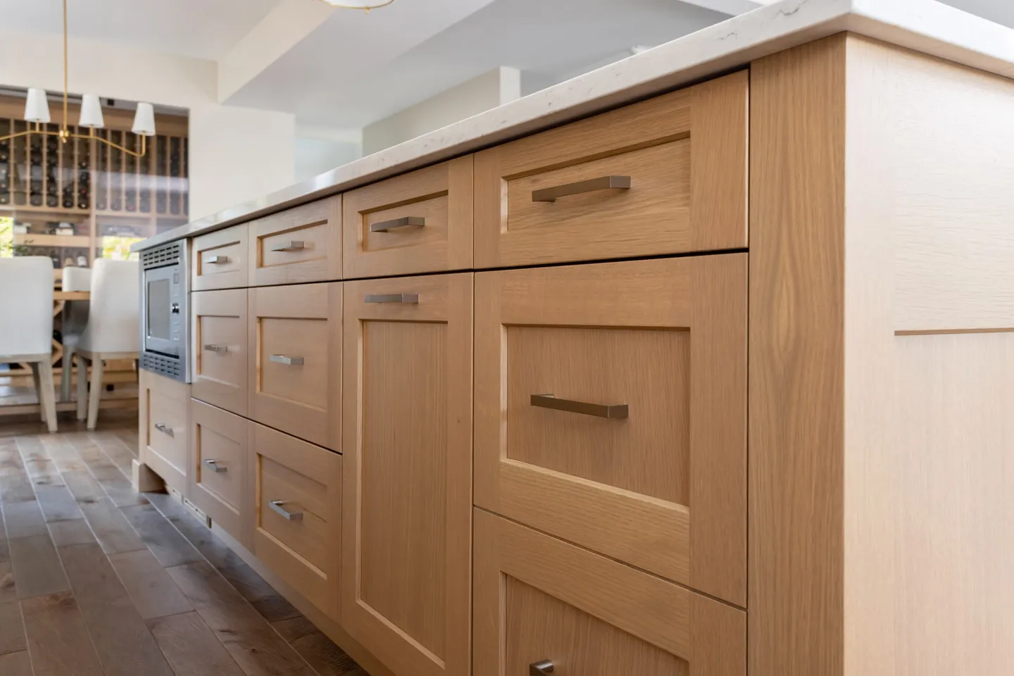 Detail of white oak island drawers with slim brass pulls