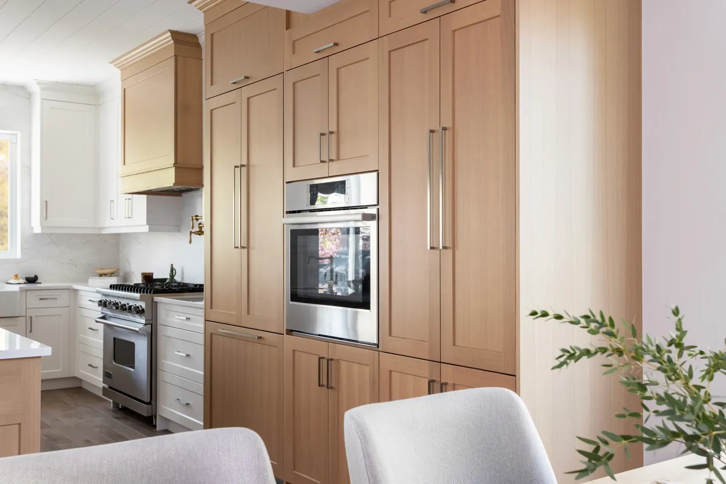 Floor-to-ceiling white oak cabinetry with integrated wall ovens